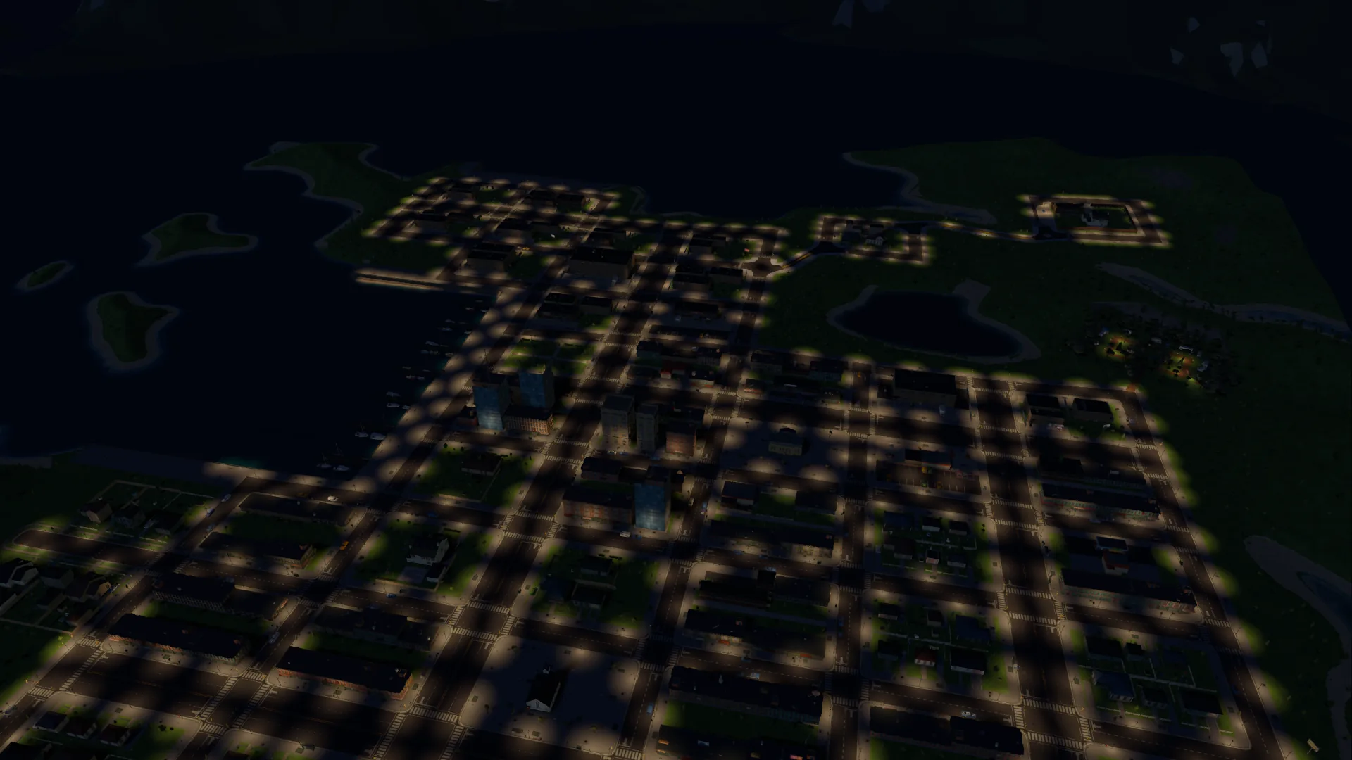 The whole town from the same height at night, every street lit by pools of lamplight