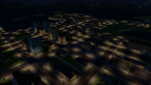 Aerial view of the town at night: street lights tracing the grid around the florist's block, downtown towers and the dark bay beyond